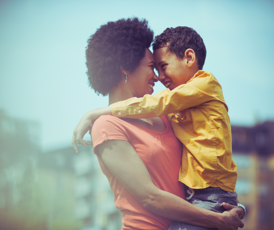Mom and child smiling and hugging.