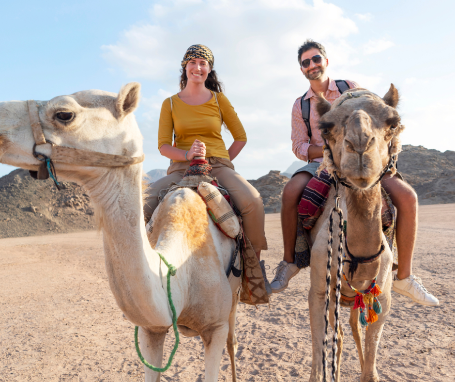 Explore Epic Land Tours: Disney, Luxury & Custom Adventures - DVC Advantages Couple riding camels in the desert.