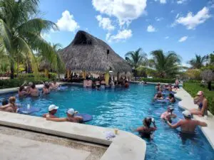 Guests enjoying drinks and celebrating at the swim-up pool bar at Mr. Sancho’s Beach Club in Cozumel, Mexico