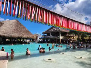 Cruise port pool area at Costa Maya with lounge chairs, palm trees, and travelers relaxing
