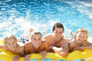 Young family having fun together in pool